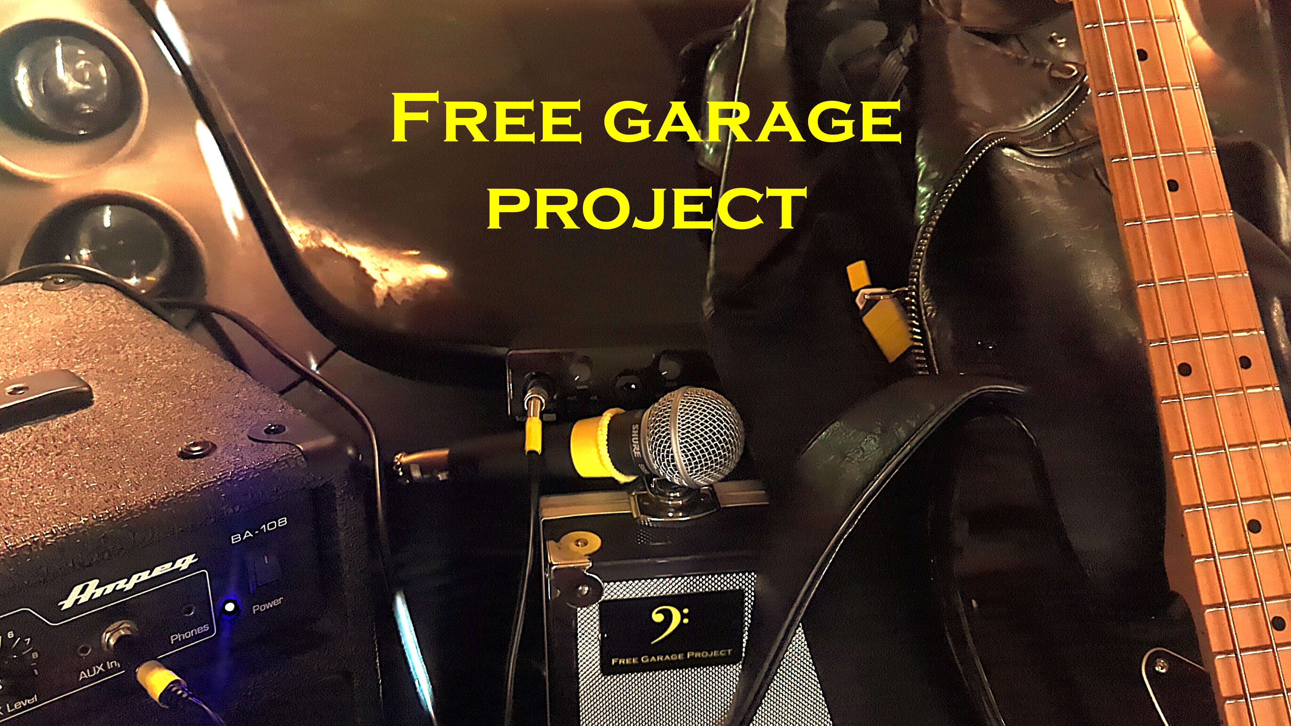 Free Garage Project i garaget med bas, mikrofon, förstärkare och projektets logotyp.